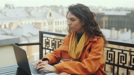 Mujer-Trabajando-En-Una-Laptop-En-La-Terraza-De-La-Azotea